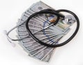 Medical treatment and cost concept: stethoscope placing on US dollars banknotes