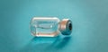 Medical vial for injection on blue background, transparent glass bottle, drug medicine vaccine dose