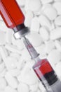 Medical vial and syringe on white pills and tablets