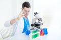 Medical man with or scientific researcher or scientist working with a microscope and test tubes in a laboratory Royalty Free Stock Photo