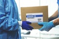 medical worker accepting delivery of covid-19 vaccines from deliveryman Royalty Free Stock Photo