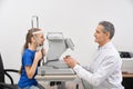 Medical worker checking eyesight of little girl in clinic