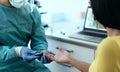 Medical worker checking glycemia test for diabetes to female patient during corona virus outbreak