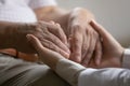 Medical worker holding hands of old 70s retired patient.