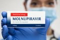 Medical worker holding medicine package box,MOLNUPIRAVIR clinical trial antiviral drug in development phase,cure for Coronavirus