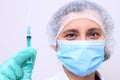 Medical worker in mask with injection. Doctor holding vaccine in syringe