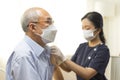 Medical worker or nurse perform a vaccine injection to senior Asian man in clinic