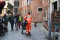 Medical worker is urging to a patient. Streets of Italian town