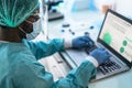 Medical worker wearing personal protective equipment using computer inside clinic during corona virus outbreak Royalty Free Stock Photo