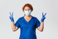 Medical workers, covid-19 pandemic, coronavirus concept. Optimistic smiling redhead female doctor, physician in medical Royalty Free Stock Photo