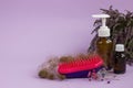 Medication bottles, hairbrush and herb heather on purple background. Hair loss problem.