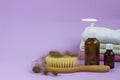 Medication bottles, hairbrush and towel on purple background. Hair loss problem.