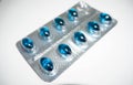 Medication in the form of a pack of blue pills on a gray background Royalty Free Stock Photo