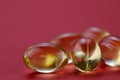 Medicinal background. Yellow omega 3 capsules on the right on a red background.