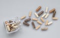 Medicinal capsule spill out of a glass jar on light surface Royalty Free Stock Photo