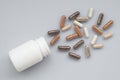 Medicinal capsule spill out of a plastic bottle on a light surfa Royalty Free Stock Photo