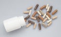 Medicinal capsule spill out of a plastic bottle on a light surfa Royalty Free Stock Photo