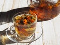 Medicinal herbal tea with dried flowers of marigold and calendula.Glass teapot and glass of brewed tea in the evening light Royalty Free Stock Photo