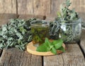 Medicinal herbal tea using dried Melissa. Dried leaves of Melissa or mint with a fresh twig and decoction in a glass on an wooden Royalty Free Stock Photo