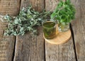 Medicinal herbal tea using dried Melissa. Dried leaves of Melissa or mint with a fresh twig and decoction in a glass on an wooden Royalty Free Stock Photo