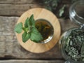 Medicinal herbal tea using dried Melissa. Dried leaves of Melissa or mint with a fresh twig and decoction in a glass on an wooden Royalty Free Stock Photo