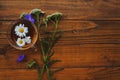 Medicinal herbs and strawberries, decoction of chamomile, yarrow and mint, tea. on a wooden background