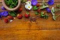 Medicinal herbs and strawberries, decoction of chamomile, yarrow and mint, tea. on a wooden background