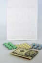 Medicinal pills, dollars on the background of the cardiogram Royalty Free Stock Photo