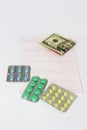 Medicinal pills, dollars on the background of the cardiogram