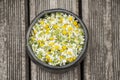 Medicinal plants- blossoms of chamomile for healthy tea in handmade mug of black pottery Royalty Free Stock Photo