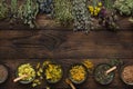 Medicinal plants bunches and row of bowls with dry medicinal herbs on brown wooden board.  Alternative medicine Royalty Free Stock Photo