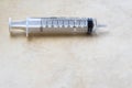 medicinal syringe without needle in horizontal position on clear base with ample copy space underneath