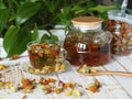 Medicinal tea made from dried flowers of calendula and marigolds on a wooden table and with green leaves in the background. The Royalty Free Stock Photo