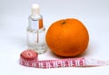 Medicine bottle with fluid, orange fruit and tailors centimeter. Weight control or slimming diet concept photo