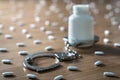 Medicine bottle handcuffed and surrounded by many pills. Royalty Free Stock Photo