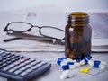 Medicine bottle, pills and financial data Royalty Free Stock Photo