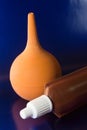 The medicine bottle with a white cap, brown bottle rests on a brilliant blue background with an orange enema Royalty Free Stock Photo