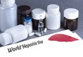 Medicine bottles, vaccine, white paper with lettering World Hepatitis Day. Cancer of the liver, Hepatitis, Hepatitis C, virus.