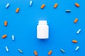 Medicine. Color capsules near pill bottle on blue background top view copy space Royalty Free Stock Photo