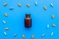 Medicine. Color capsules near pill bottle on blue background top view copy space Royalty Free Stock Photo