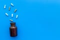 Medicine. Color capsules near pill bottle on blue background top view copy space Royalty Free Stock Photo