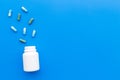 Medicine. Color capsules near pill bottle on blue background top view copy space Royalty Free Stock Photo