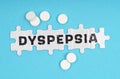 On a blue background pills and puzzles with the inscription - DYSPEPSIA