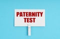 On a blue background, there are pills and a business card with the inscription - paternity test
