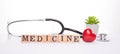 Medicine concept. Close up panoramic banner photo of doctor tool plant red heart and wooden blocks making text medicine isolated