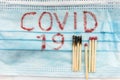 Medicine concept covid 19 write on medical mask with matches bacteria 2019-ncov on white background. Coronavirus as danger disease Royalty Free Stock Photo