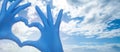 Medicine concept with heart build hands in medical gloves on blue sky background Royalty Free Stock Photo
