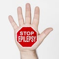 On the palm of the hand there is a stop sign with the inscription - STOP EPILEPSY. Isolated on white background