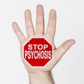 On the palm of the hand there is a stop sign with the inscription - STOP PSYCHOSIS. Isolated on white background