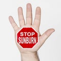 On the palm of the hand there is a stop sign with the inscription - STOP SUNBURN. on white background